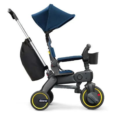 Royal Blue Doona - Liki Trike S3 showcasing a compact trike with a sunshade, storage bag, and yellow-accented wheels.
