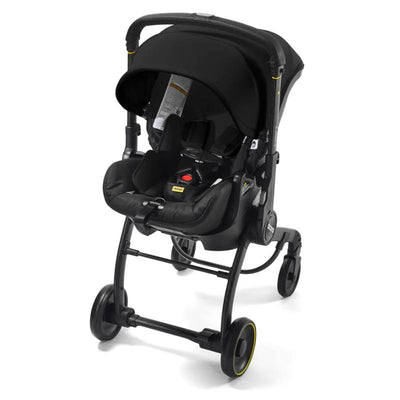 Doona X Infant Car Seat & Latch Base in Nitro Black, featuring a sleek design with safety buckles and a removable canopy.