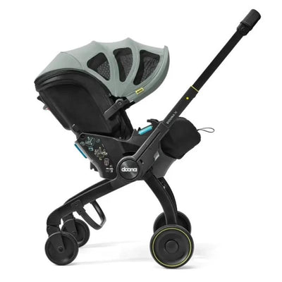 Doona X Summer Canopy in Dusty Sage, featuring a sleek infant car seat with a protective canopy and stroller wheels.