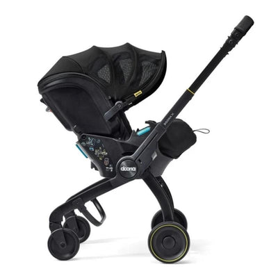 Doona X Summer Canopy in Nitro Black, featuring a sleek design, adjustable canopy, and attached child safety seat.