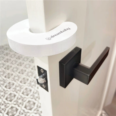 Dreambaby Foam Door Stoppers, white, attached to a door to prevent it from closing accidentally.