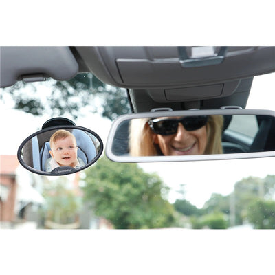 Baby in rear-view mirror of car, smiling, while an adult with sunglasses smiles in the front mirror.