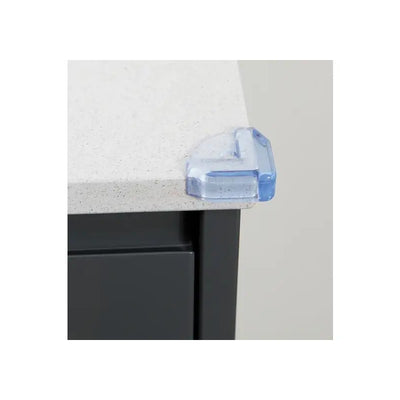 Clear corner cushion placed on the edge of a light-colored tabletop to enhance safety for children.
