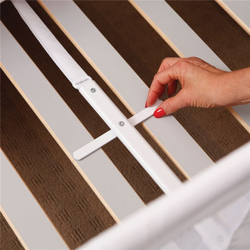 Hand adjusting the white Dreambaby Savoy Bed Rail, with wooden slats visible beneath.