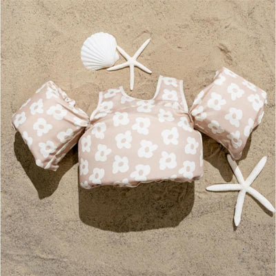 Kids float with flower pattern lying on sand, accompanied by starfish and a seashell. Suitable for 25-50 lbs.
