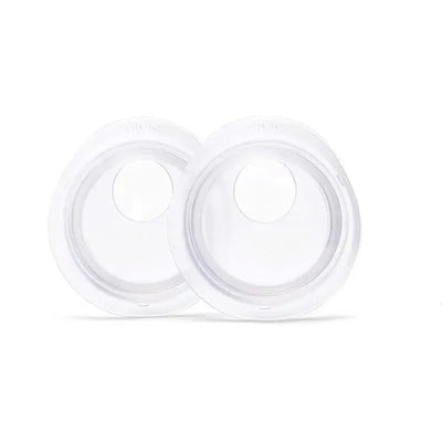 Two transparent milk collection cups from Elvie, designed for secure milk collection during breastfeeding.