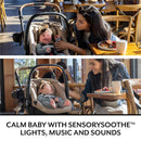 Evenflo Shyft Intuiti Travel System with LiteMax NXT Infant Car Seat, featuring a calm baby and a parent interacting in a café.
