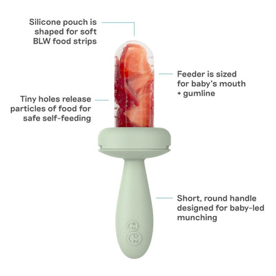 Sage-colored ezpz Baby Led Gumline Feeder with a silicone pouch for soft food strips and a short handle for self-feeding.