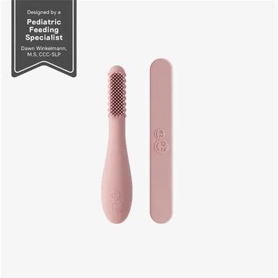 Baby-Led™ Toothbrush and Sensory Tongue Depressor in blush, designed for infants, featuring textured bristles and a smooth handle.