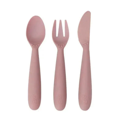Blush-colored set of three utensils: a spoon, fork, and knife, designed for young children.