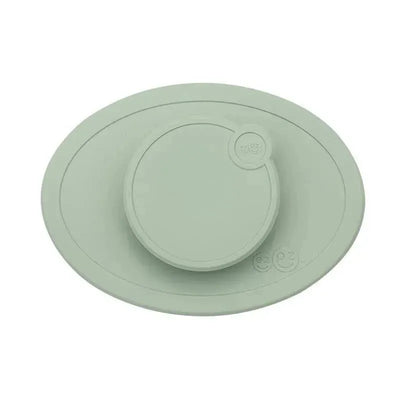 Tiny Bowl Lid by Ezpz in sage green, featuring a round center section with an oval base for secure food cover.