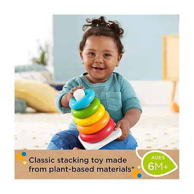 Smiling child holding a Fisher Price Eco Rock-a-stack toy with colorful rings, designed for children aged 6 months and older.