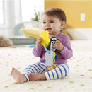 Child sitting on a soft rug, holding Fisher Price Laugh & Learn toy keys with colorful attachments, smiling.