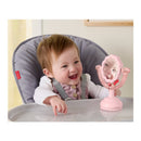 A happy baby in a high chair interacts with a pink tabletop mirror, part of the Fisher Price Mini Me playset.