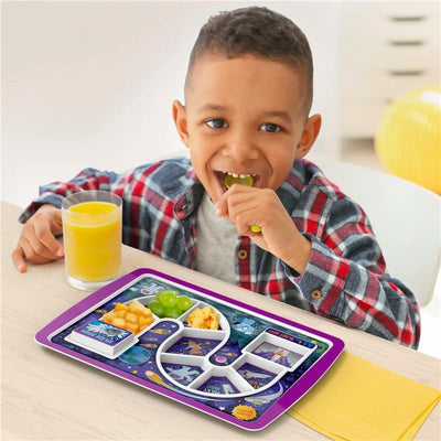 Young boy enjoying a meal on a Fred & Friends space-themed plate, featuring colorful food and a glass of juice.