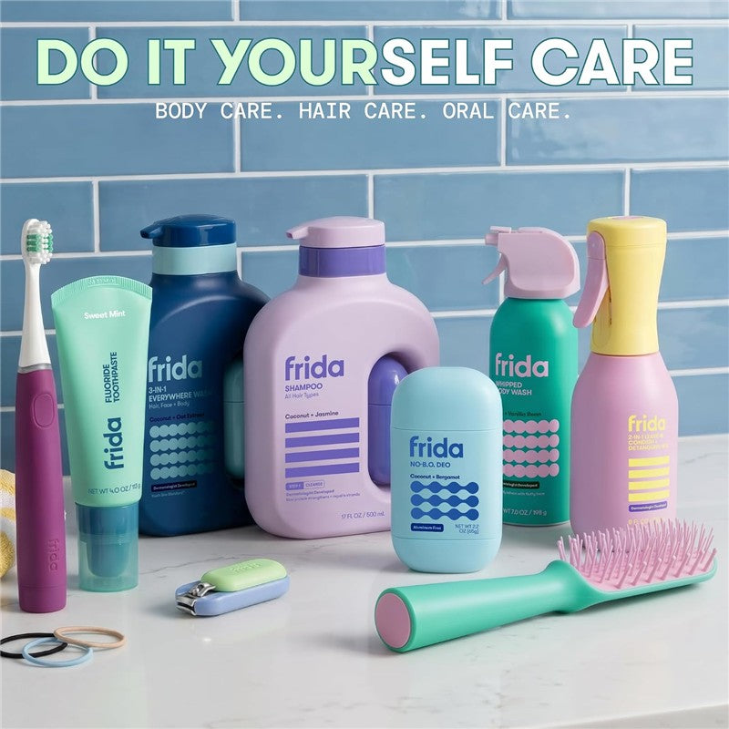 Frida for Kids body wash, shampoo, deodorant, and oral care products arranged on a white countertop against a blue tiled background.