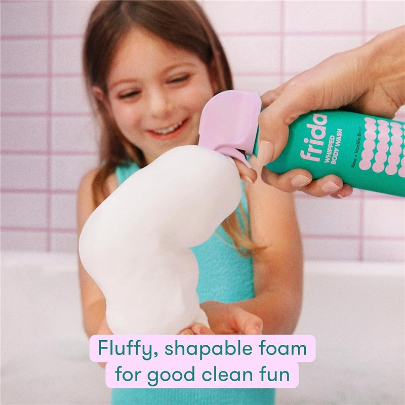 Frida for Kids Whipped Body Wash bottle held by an adult, dispensing fluffy foam while a smiling child enjoys bath time.