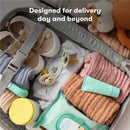 Travel bag containing baby essentials: clothing, pacifiers, wipes, lotion, and a stuffed animal, designed for delivery day.