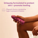 Frida Mom Anesthetic Spray in a purple bottle, designed for postpartum skin protection and healing, held by a hand.