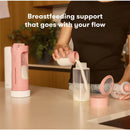 Frida Mom Flow + Go Breastmilk Cooler on a kitchen counter, with a person pouring breastmilk into a container.
