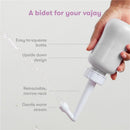 Gray Frida Mom Upside Down Peri Bottle sprayer held by a hand, demonstrating a gentle warm stream of water for postpartum care.