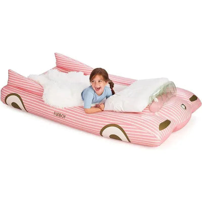 Kids pink inflatable travel bed and mattress with a smiling girl laying on it, featuring a fluffy blanket and pillow.