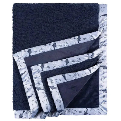 Plush navy blue blanket with whale pattern trim, designed for comfort and warmth. Ideal for baby bedding.