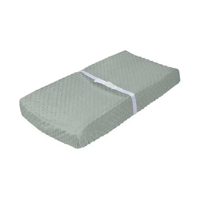 Green changing pad cover by Gerber, featuring a textured surface and secured with a white strap.