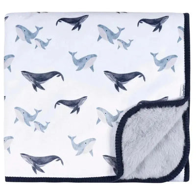 Plush blanket featuring a whale print in blue and gray with a soft gray underside and dark trim.