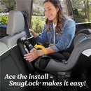 A woman installs the Graco EasyTurn 360 2-in-1 Rotating Convertible Car Seat using the SnugLock® system in a vehicle.