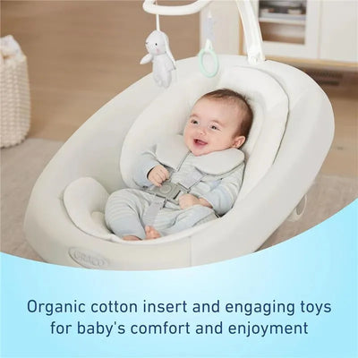 Graco Smartsense Swing with Cry Detection, featuring a smiling baby in an organic cotton insert and engaging toys.
