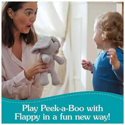 A woman joyfully plays with a Flappy Elephant plush toy with a toddler in a cozy, bright room.