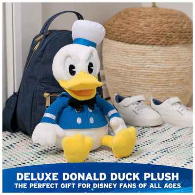 Deluxe Disney official Donald Duck plush toy with blue outfit and white hat, set near a backpack and shoes.