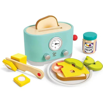 Wooden toy toaster by Hape with two slices of bread, cheese, fruit, and a jar of peanut butter, promoting imaginative play.