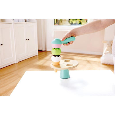 Colorful Hape Scoop & Serve Ice Cream Set, featuring stacked ice cream scoops and a serving scoop, on a table.