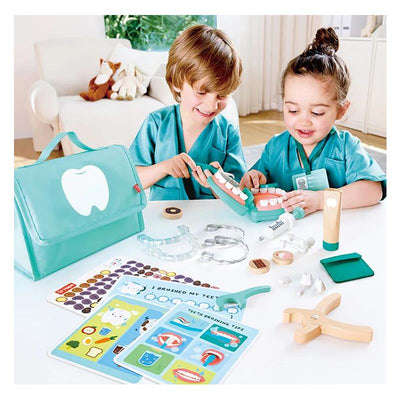 Children explore dental care with the Hape Super Smile Dental Clinic Set, featuring toy teeth, tools, and educational cards.