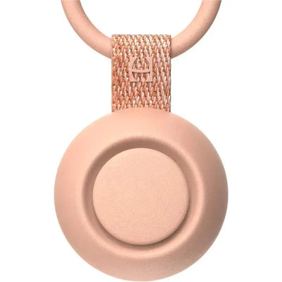 Portable peach-colored sound machine for babies with a circular design and a fabric strap.
