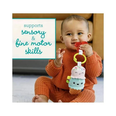 Plush ice cream toy and red teether held by a baby, highlighting sensory and fine motor skills development.