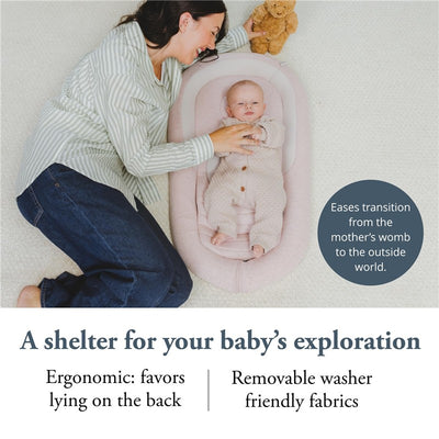 Inglesina Welcome Pod Lounger in Delicate Pink with a baby resting inside, and a smiling mother beside, highlighting ergonomic design and ease of use.