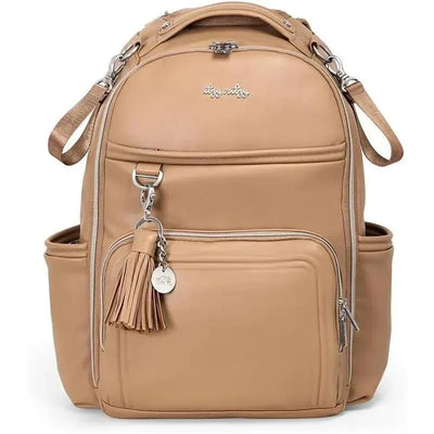 Chai Latte Boss Plus™ Backpack Diaper Bag in beige with a tassel, featuring multiple pockets and straps for convenience.
