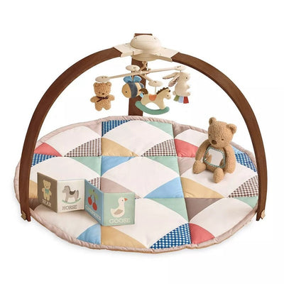 Itzy Ritzy Music & Motion Activity Gym featuring a bear, colorful quilt, hanging toys, and soft cubes with animal illustrations.