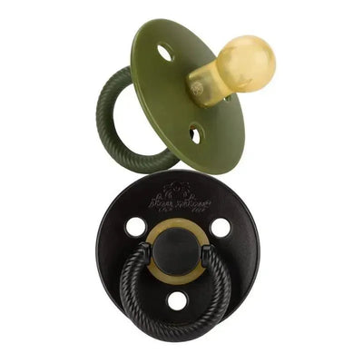 Natural rubber pacifiers in camo green and midnight black, featuring textured rings and round shields.