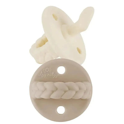 Orthodontic silicone pacifiers in Toast and Buttercream colors, featuring a braided design and minimalistic aesthetic.