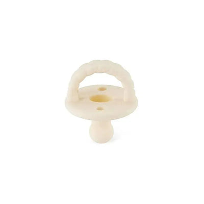 Orthodontic silicone pacifier in soft buttercream color, designed for infants, featuring a textured handle.