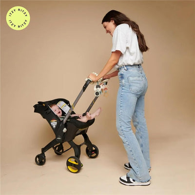 Itzy Ritzy Spiral™ Car Seat Activity Toy attached to a stroller with a smiling baby inside, while a woman pushes it.