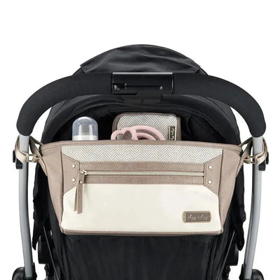 Stroller caddy in Vanilla Latte color attached to a stroller, featuring pockets for a bottle and essentials.