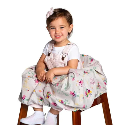 Shopping cart and high chair cover in pastel colors with floral patterns, being used by a smiling toddler in a high chair.