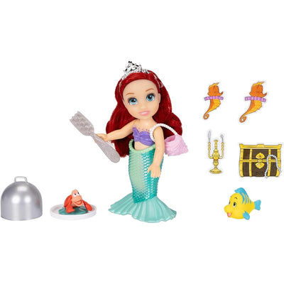 Ariel doll in a mermaid outfit holding a fork, with accessories including Sebastian the crab, a treasure chest, and sea creature stickers.