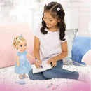 A young girl with curly hair plays with a 14-inch Cinderella doll, drawing in a notebook on a fluffy carpet.