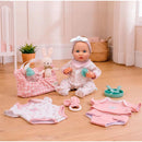 16-inch weighted reborn baby doll wearing a pink outfit, surrounded by clothing sets, bottles, and a stuffed bunny.